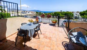 taras ze stołem i krzesłami na balkonie w obiekcie SunRise Den, a pie de playa, vista al mar y piscina w mieście Puerto de Mazarrón