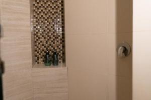 a bathroom with a shower with two wine bottles at Infinity Suites triple room 212 in Cancún