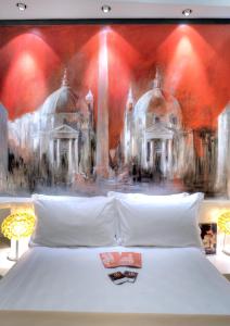 ローマにあるBdb Luxury Rooms San Pietroのベッドの上に絵画が描かれたベッドルーム1室