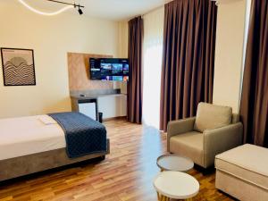 a hotel room with a bed and a chair at Orb Inn in Sarandë