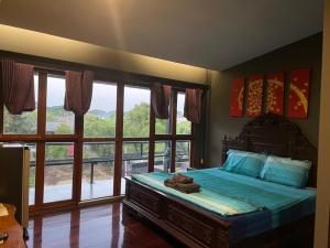 a bedroom with a bed with a large window at Baan mae khian homestay in Phra Nakhon Si Ayutthaya