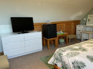a bedroom with a bed and a television on a dresser at Rockvilla Guest House in Lerwick
