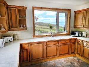 een keuken met een spoelbak en een raam bij Sunnyhill Cottage in North Erradale