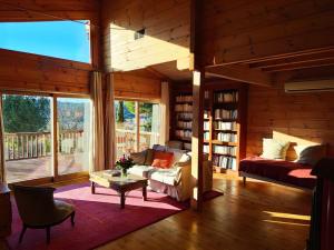 un salon avec un canapé, un lit et une table dans l'établissement Les cigales magnifique maison en bois avec piscine, à Portel-des-Corbières