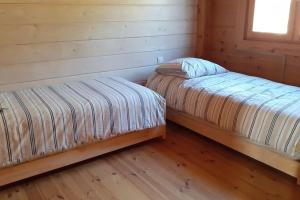deux lits dans une chambre avec parquet dans l'établissement Les cigales magnifique maison en bois avec piscine, à Portel-des-Corbières