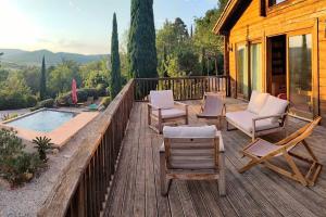 une terrasse avec des chaises et une piscine sur une maison dans l'établissement Les cigales magnifique maison en bois avec piscine, à Portel-des-Corbières