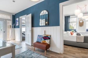 a bedroom with blue walls and a bed with a chair at 90 RELAX HOMEDESIGN Apartment in Elmshorn bei Hamburg in Elmshorn
