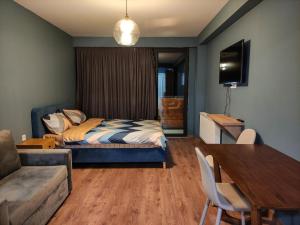 una camera da letto con un letto, un tavolo e un divano di Gudauri Twins Blues - Mountain View a Kʼumlistsʼikhe
