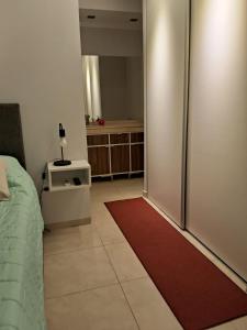 una camera da letto con una porta scorrevole in vetro con un tappeto rosso di CAPi 3 Barrio La Rosada con Cochera a Corrientes