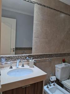 un bagno con lavandino, specchio e WC di CAPi 3 Barrio La Rosada con Cochera a Corrientes Altre 5 foto