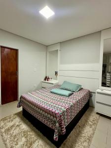 una camera da letto con un letto con una coperta colorata sopra di Casa a Rio Branco