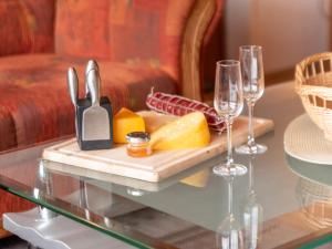 a tray of food and wine glasses on a glass table at Apartment Silbermöwe by Interhome in Norddeich