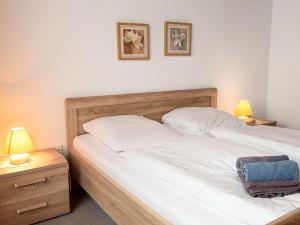 two beds in a bedroom with two lamps and a bag at Apartment Silbermöwe by Interhome in Norddeich