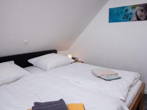 a bedroom with two white beds and a painting on the wall at Apartment Nordsee Brise by Interhome in Norden