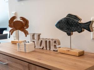 a shelf with a fish and a sign that says fame at Apartment Nordsee Brise by Interhome in Norden