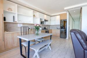 a kitchen with a table and a vase of flowers at Portico 1006 Beachfront Apartment with Panoramic Views in Cape Town