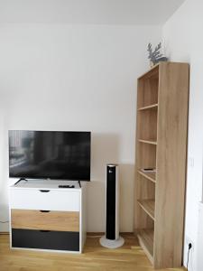 a living room with a tv and a book shelf at Bright Apartment in Munich Within Sight of Alps in Munich