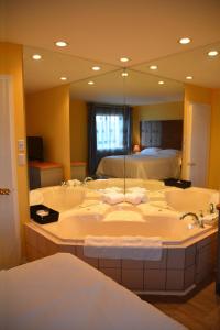 a bathroom with two sinks and a large mirror at Motel des Pentes et Suites in Saint-Sauveur-des-Monts
