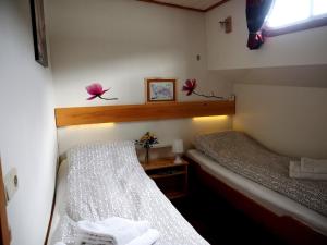 アムステルダムにあるホテルボート アリューアのベッド2台と窓が備わる小さな客室です。