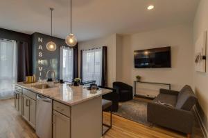 Una cocina con fregadero y una sala de estar. en Lovely Rooftop-Game Room-Sleep 8, Near The Opry, en Nashville