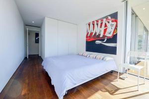 a bedroom with a bed and a painting on the wall at Casa do Casal in Moledo