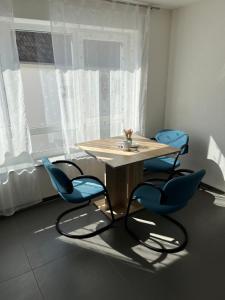 a table and two blue chairs in a room at MW Apartments B1 in Lauchheim