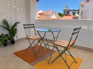 deux chaises et une table sur un balcon dans l'établissement Setubal Terrace apartments, à Setúbal