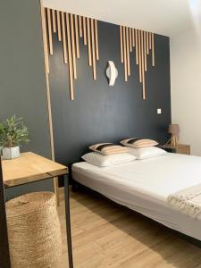 a bedroom with a bed and a table and a wall at Résidence 3 étoiles Pietra Gemina - Appartements de vacances, au calme, avec Piscine in Calenzana