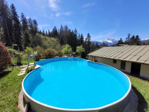 a large blue swimming pool in the yard of a house at das.arnolds | Whirlpool | Pool | Bergblick in Berchtesgaden