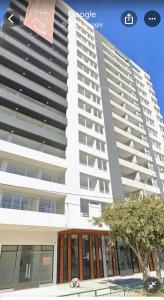 ビーニャデルマールにあるA pasos de Sporting Viña del mar para celebrar este 18 de Sept!の前に木がある背の高い白い建物