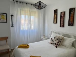 イスランティージャにあるApartamento en Islantilla playa con 2 terrazas y WIFI FIBRAの白いベッドと窓のある寝室 +24枚の写真