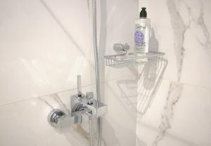 a shower with a glass door with a bottle of soap at Glyfada Relax 8 in Athens