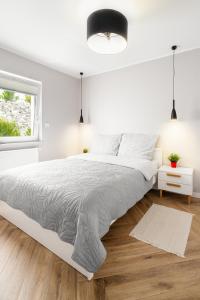 una camera da letto bianca con un letto grande e una finestra di Apartament Stacja Wisła a Wisła