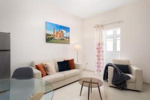 un soggiorno con un divano e un tavolo di vetro di Modern 2BD Apartment with Maltese Balcony & Back Yard - Close to St Julian's & St Georges Bay & Sliema Promenade a Il-Gżira
