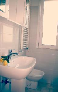 łazienka z białą umywalką i toaletą w obiekcie Hotel Amoha w Rimini +37 zdjęć