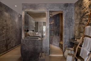 a bathroom with a large stone tub and a sink at Hippie Chic Hotel in Agios Ioannis Mykonos