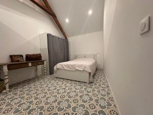 a bedroom with a bed and a tiled floor at Les jardins de Reville in Réville