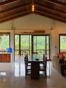 a dining room with a table and chairs and a couch at Paraíso selvático Casa de campo in Sucúa