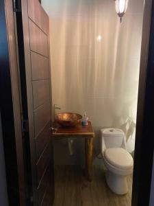 a bathroom with a toilet and a bowl on a table at Paraíso selvático Casa de campo in Sucúa +15 photos