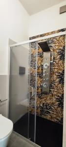 a bathroom with a shower with a toilet and a wall at B&b S'Erbei Niedda Guesthouse in Seùlo +28 photos
