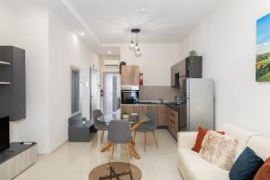 un soggiorno e una cucina con un divano e un tavolo di Modern 2BD Apartment with Maltese Balcony & Back Yard - Close to St Julian's & St Georges Bay & Sliema Promenade a Il-Gżira