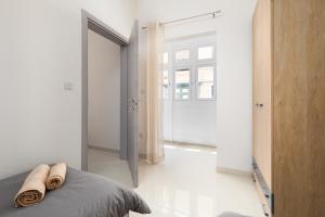 una camera da letto con un letto con due asciugamani sopra di Modern 2BD Apartment with Maltese Balcony & Back Yard - Close to St Julian's & St Georges Bay & Sliema Promenade a Il-Gżira
