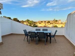イスランティージャにあるApartamento en Islantilla playa con 2 terrazas y WIFI FIBRAのバルコニーにテーブルと椅子が置かれたパティオ