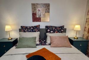 a bedroom with two beds with pillows and two lamps at Ferienwohnung GoodTimes in Hausen über Aar