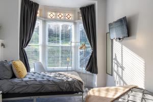 Un dormitorio con una cama y una ventana grande. en Flat 1, Church House, en Ilfracombe