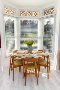 Un comedor con mesa y sillas y ventanas. en Flat 1, Church House, en Ilfracombe