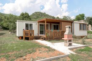 a tiny house in a yard with a porch at Tiny House Kety in Krupa