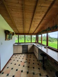 a kitchen with a large counter and some windows at Encantador refugió natural in Santa Rosa de Viterbo
