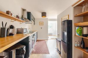 a kitchen with a counter and a refrigerator at Quiet, charming countryside retreat nr. the capital of the Cotswolds in Cirencester