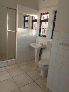 a white bathroom with a toilet and a sink at Mlawu Guest House in Margate +10 photos